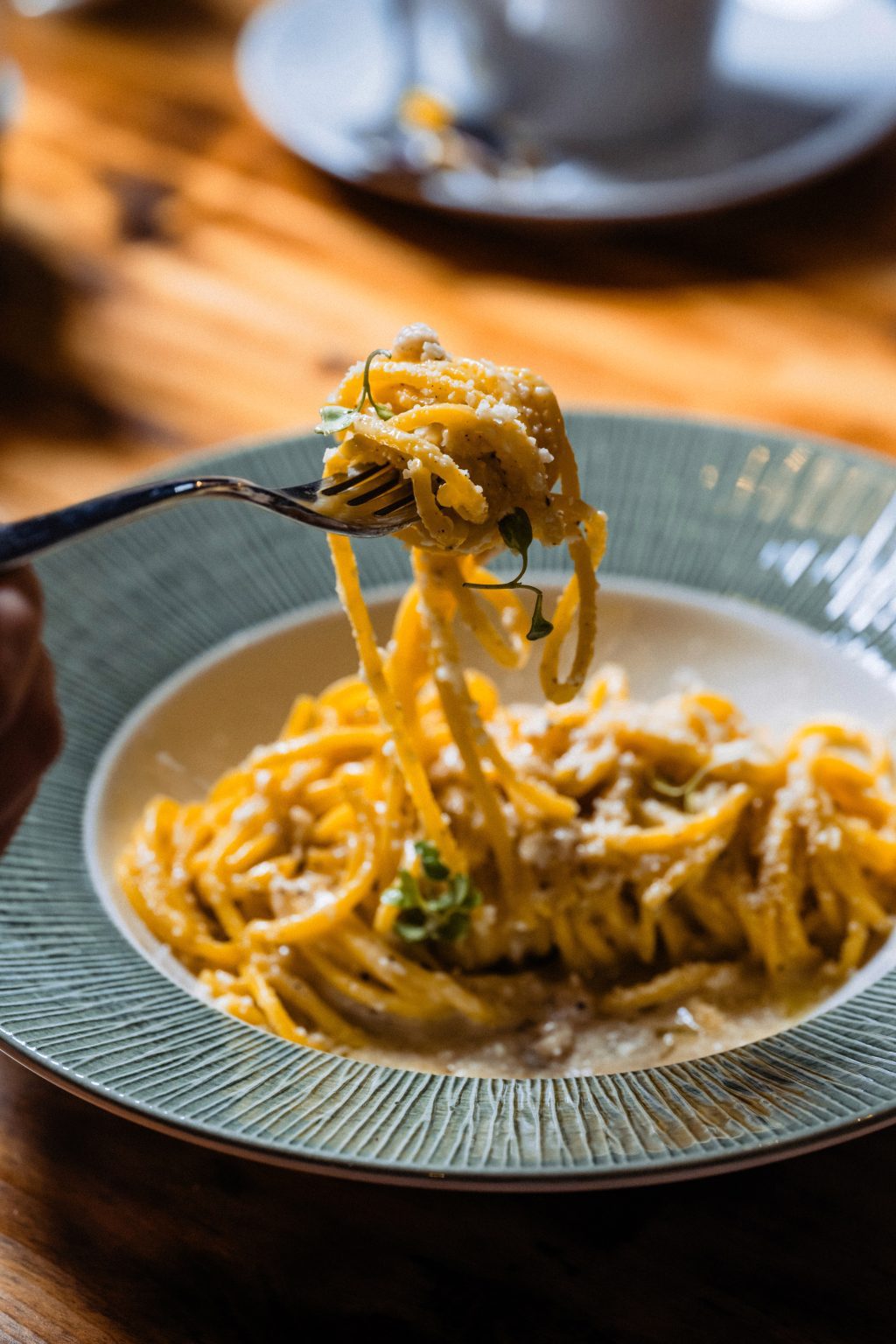Spaghete răsucite pe furculiță, deasupra farfuriei