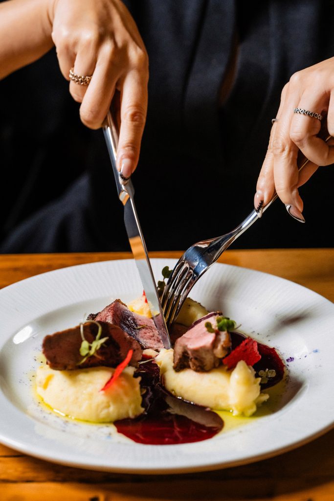 Felii de carne pe piure, cu sos de fructe roșii, tăiate la masă
