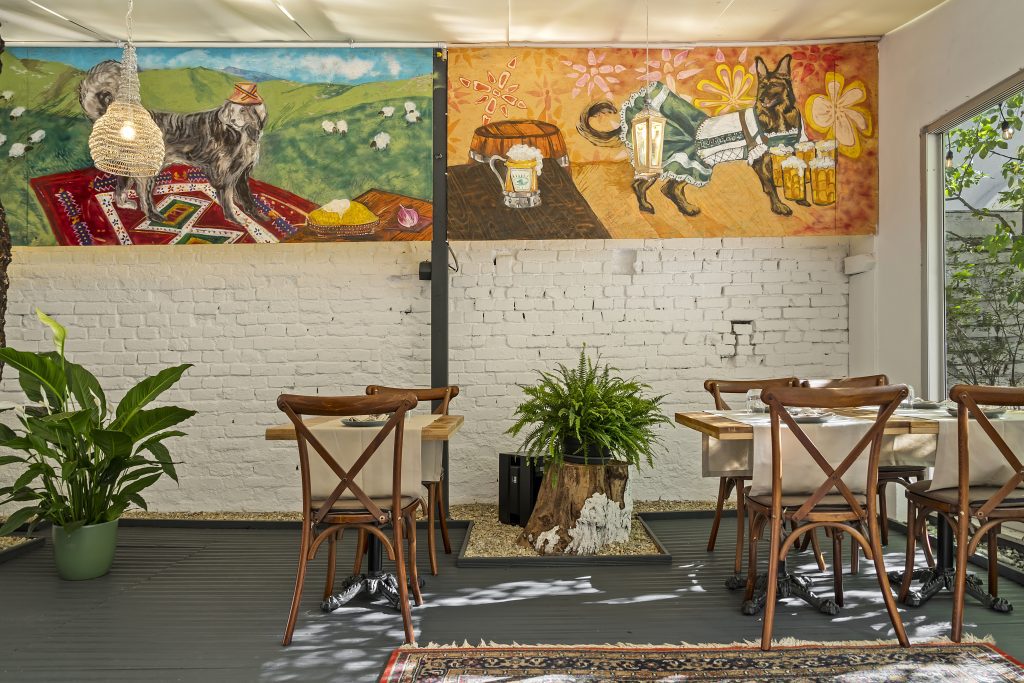 Sala cu pictură murală și mese de lemn