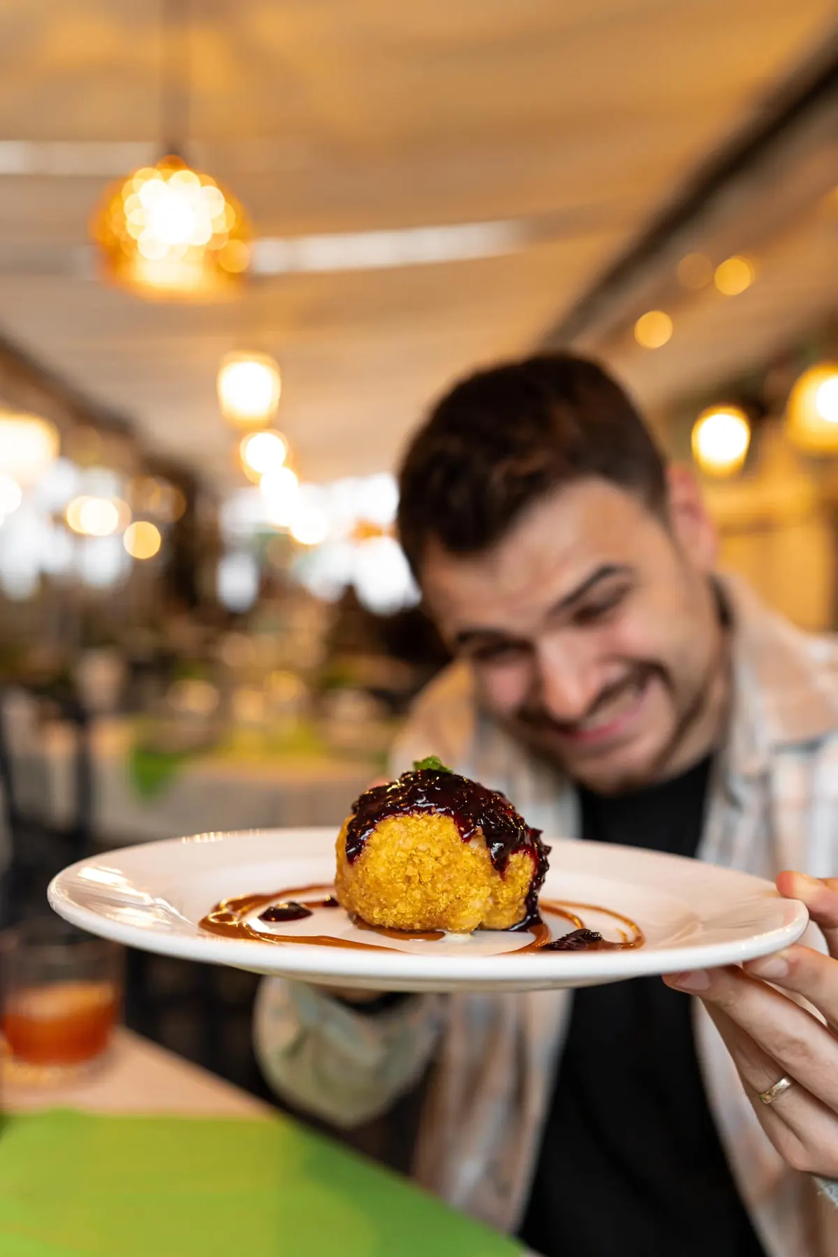 Bărbat zâmbind, cu un desert de ciocolată pe farfurie