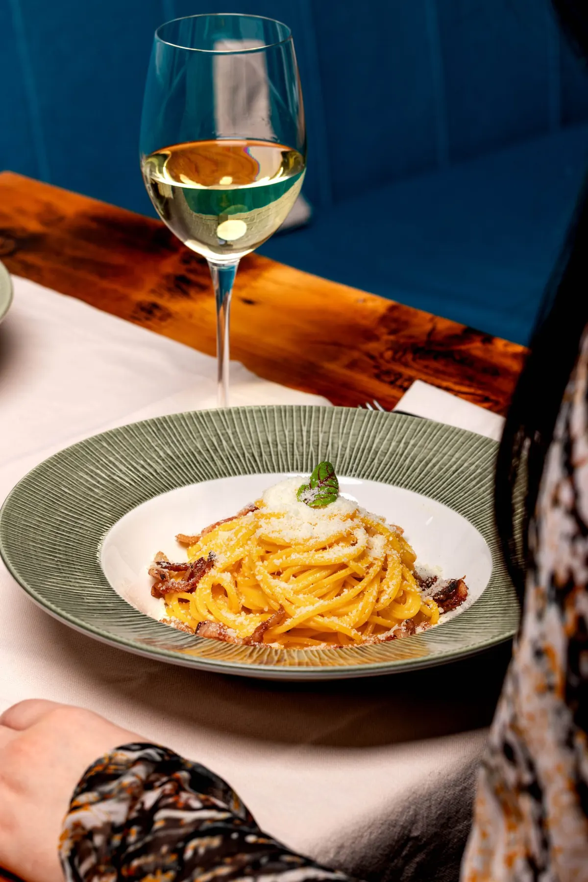 Spaghete carbonara, lângă un pahar de vin alb