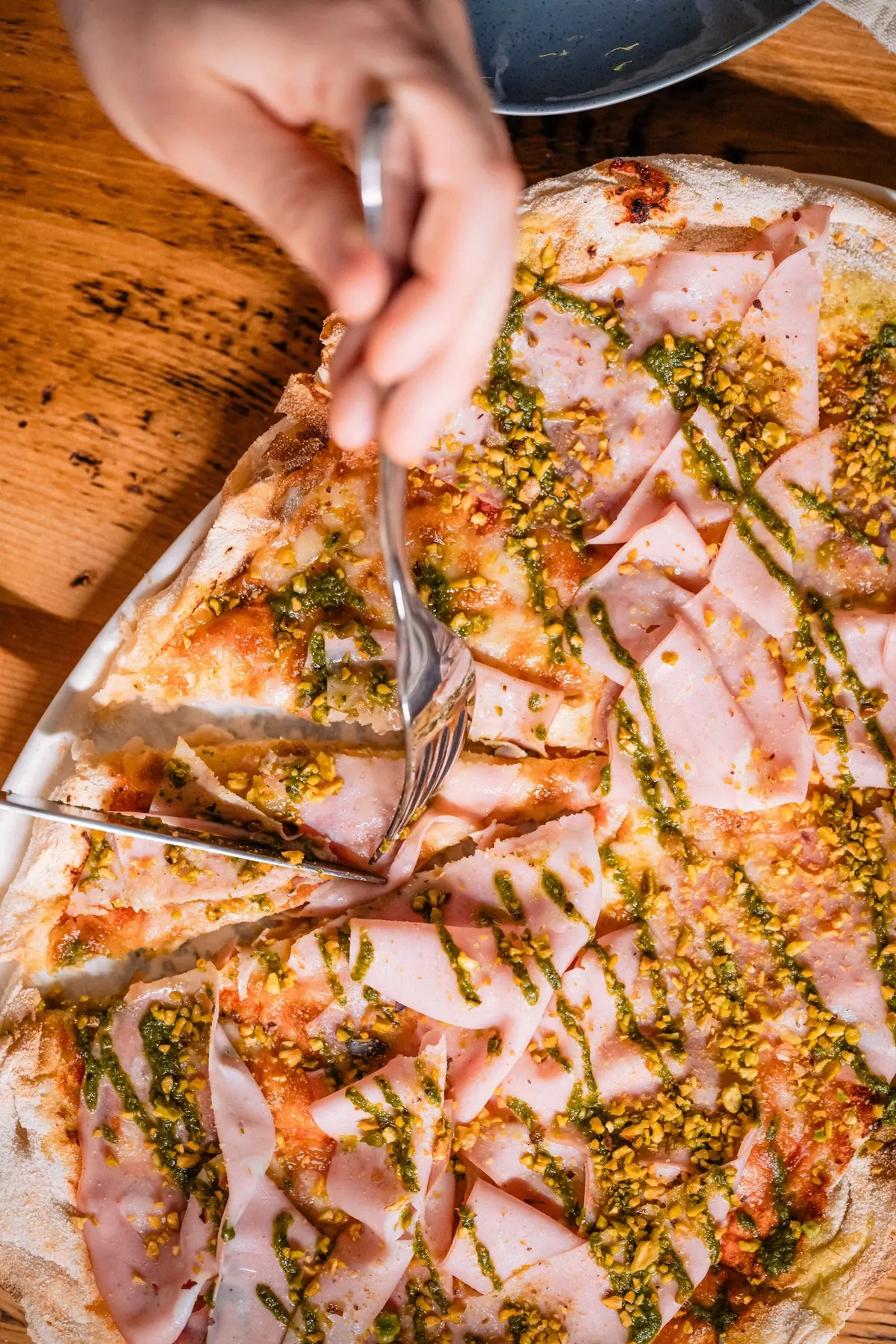 Pinsa cu mortadella și pesto de fistic, tăiată în felii