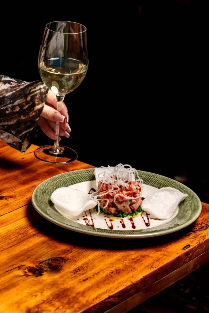 Tartar de ton cu chipsuri, lângă un pahar de vin alb